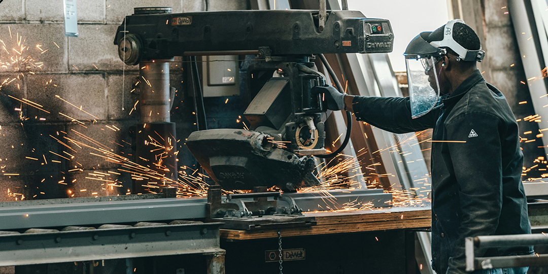 linea-de-produccion-industrial un trabajador de una fabrica trabajando con maquinaria especializada para cortar metal en una planta digitalizada